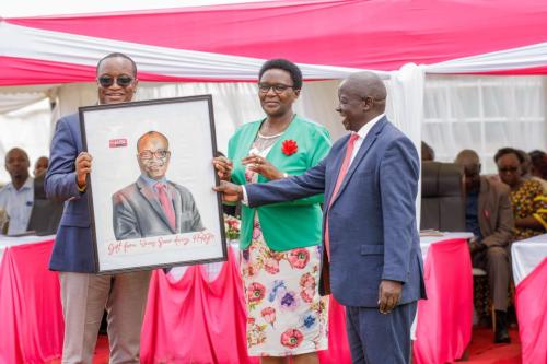 Chairman  Ceo of Winas sacco presents a potrait to Chief guest Mr. Marangu ( Director Cop Bank) during the Sacco AGM-min